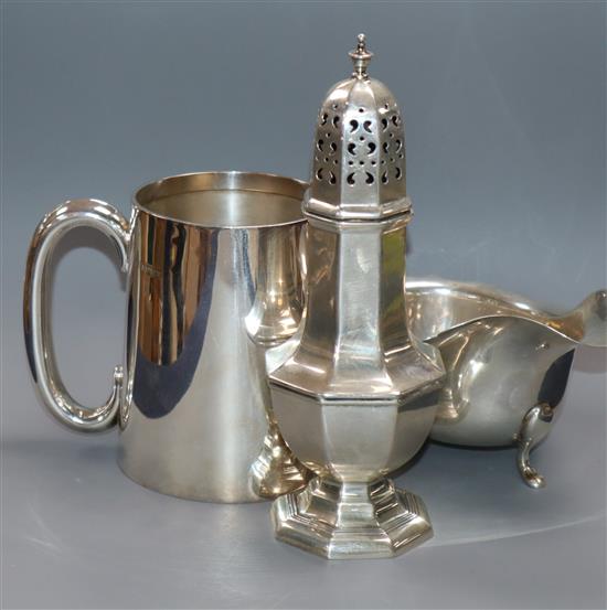 A modern silver mug, a George V silver sugar caster and similar sauce boat, 17.5 oz.